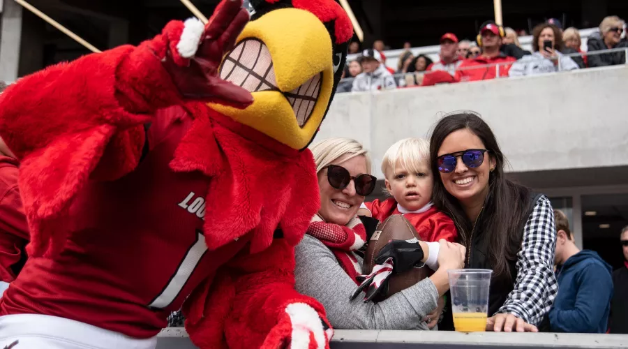 Louie poses with fans at a football game