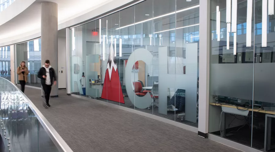 Students walking down a hallway in the Belknap Academic Building near REACH