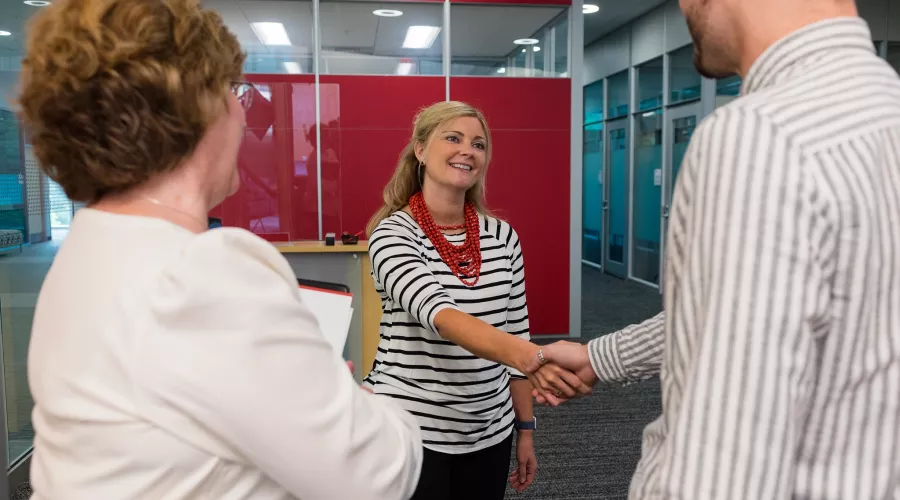 Male being introduced to female employee, shaking hands