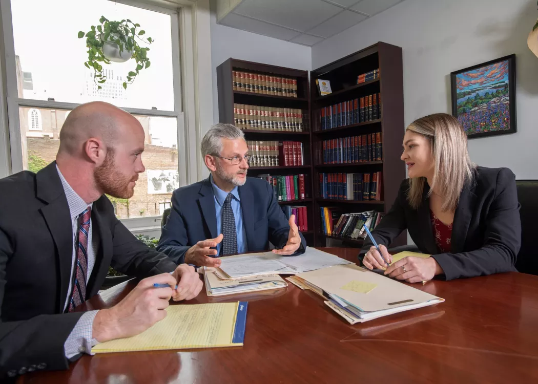 Alumni and students discuss a case at the Ackerson Law Clinic