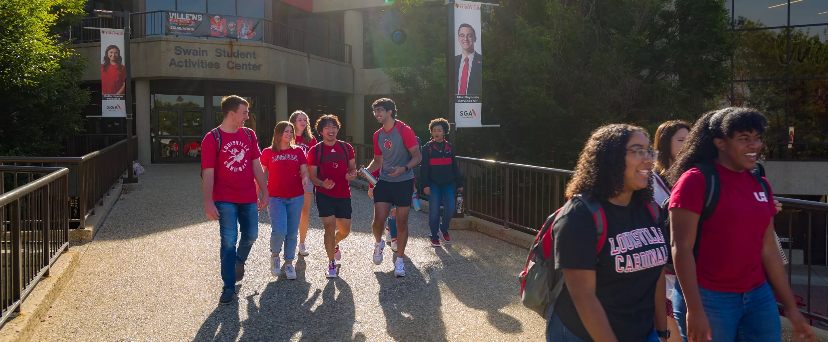 A group of students exiting the Student Activities Center on a sunny morning