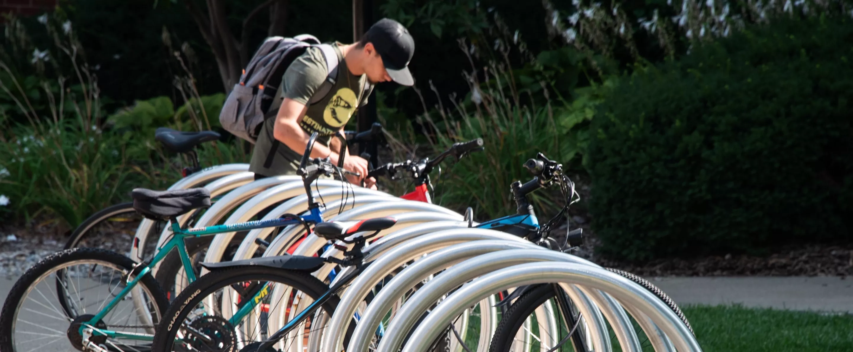 Student locking his bike into a bike rack on Belknap Campus