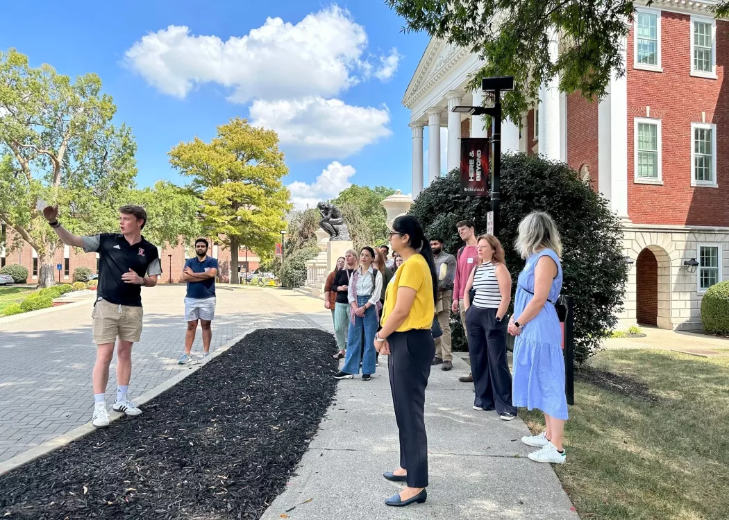 New Employee Orientation group touring Belknap Campus out front of Grawemeyer Hall