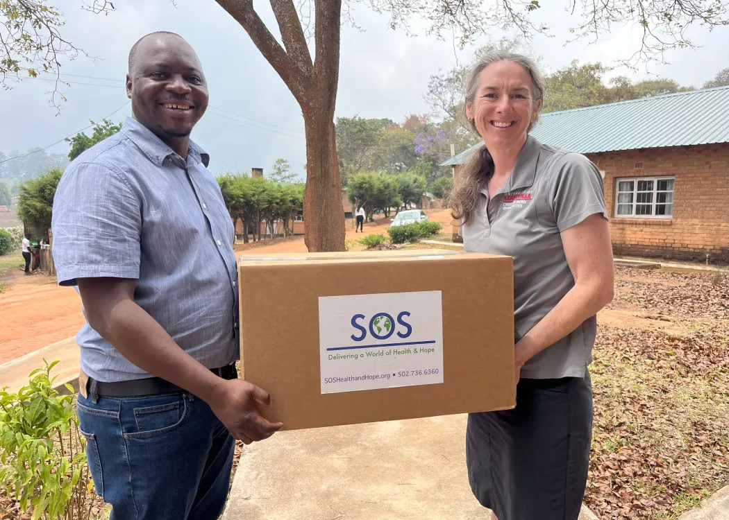 Man and woman holding a box of medical and research supplies in Malawi